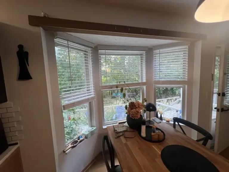 Bay window in a dining area, illustrating window replacement costs.