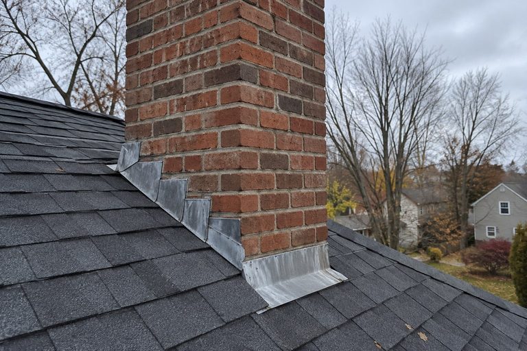 Brick chimney and step flashing on an asphalt shingle roof in Central Ohio